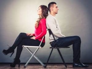 Bad relationship concept. Man and woman in disagreement. Young couple after quarrel sitting on chairs back to back